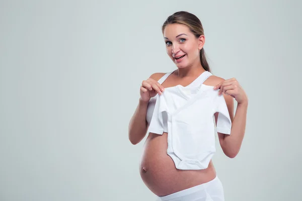 Pregnant woman holding a baby t-shirt — Stock Photo, Image