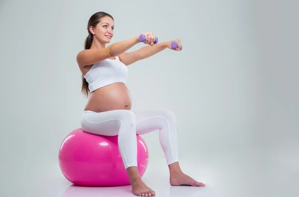 Woman doing exercises with dumbbells on a fitness ball — 图库照片