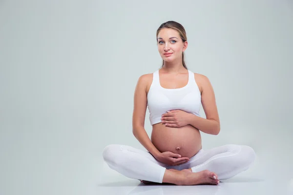 Pregnant woman sitting on the floor — Stock Photo, Image