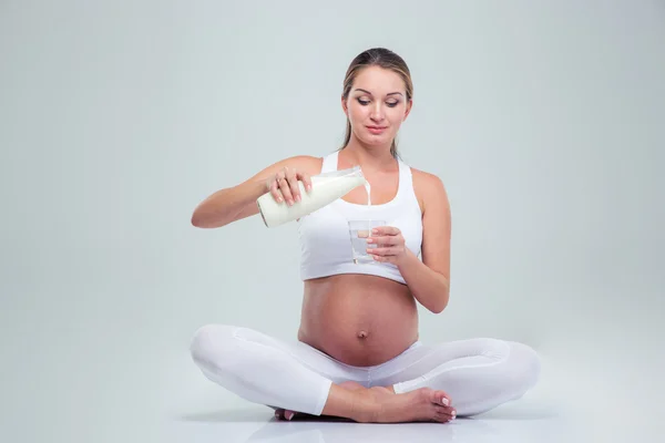 Woman sitting on the floor and drinking milk — Stok fotoğraf