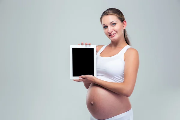 Mulher grávida mostrando tela do computador tablet — Fotografia de Stock