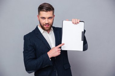 Handsome businessman showing blank clipboard