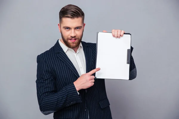 Handsome businessman showing blank clipboard — Stok fotoğraf