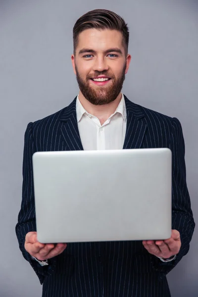 Retrato de un empresario feliz sosteniendo el ordenador portátil — Foto de Stock