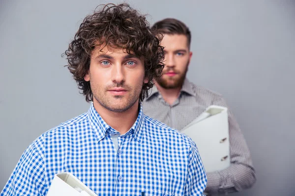 Two serious businessmen holding folders — Zdjęcie stockowe