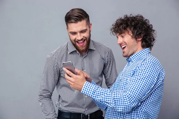 Dos hombres riendo usando smartphone — Foto de Stock
