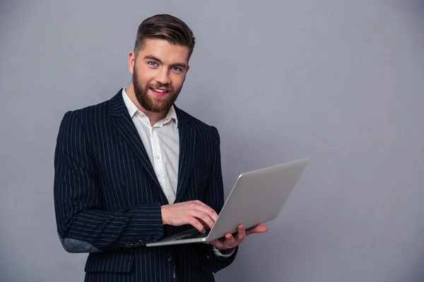 Retrato de un hombre de negocios sonriente usando lapto — Foto de Stock