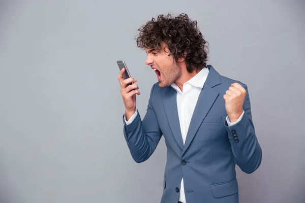 Angry businessman shouting on smartphone — Stock Photo, Image