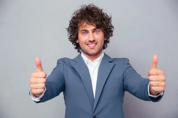 Smiling businessman standing with thumbs up — Stockfoto