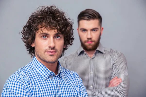 Two handsome businessmen standing with arms folded — Stock Photo, Image