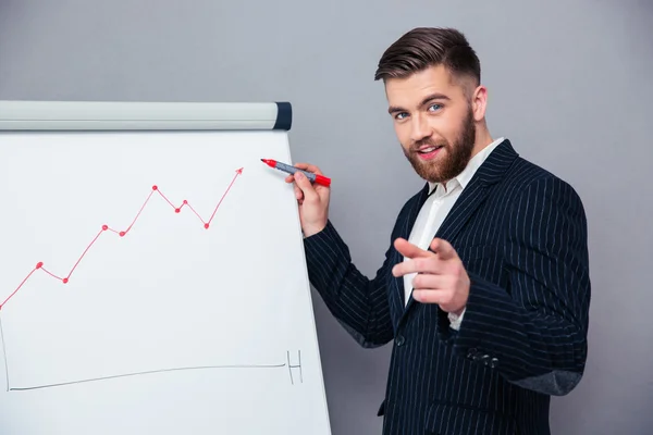 Businessman presenting something on board — Stock fotografie