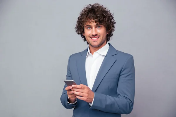 Businessman holding smartphone and looking at camera — Zdjęcie stockowe