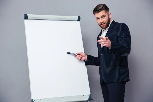 Uomo d'affari che presenta qualcosa sul tabellone bianco — Foto Stock