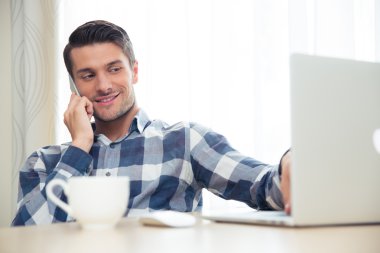 Adam telefonda konuşurken ve dizüstü evde kullanma