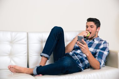 Smartphone ve yeme elma kullanan adam