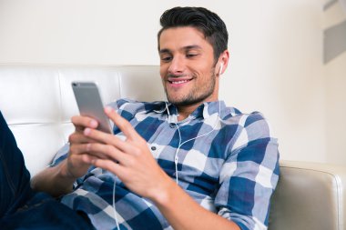 Smartphon ile kanepede yatan adam