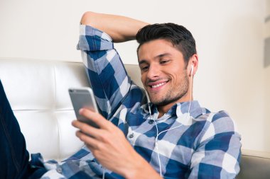 Kanepede Smartphone kullanan adam
