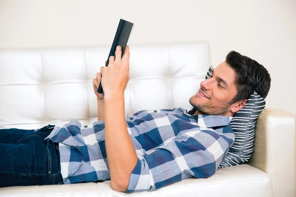 Mann liest Buch auf dem Sofa — Stockfoto