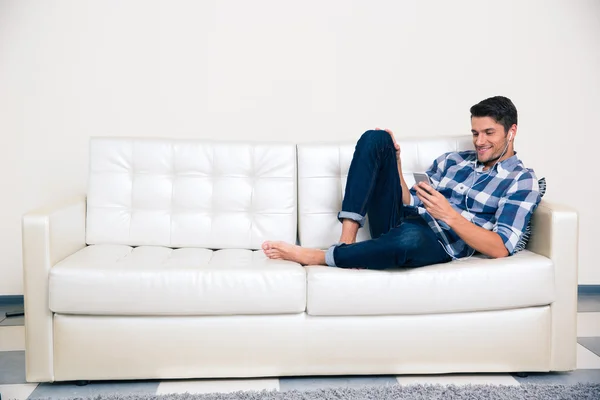 Hombre usando smartphone en el sofá —  Fotos de Stock