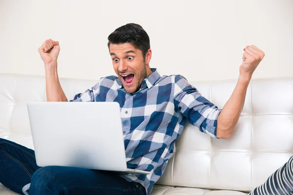 Homem animado procurando jogo no laptop — Fotografia de Stock