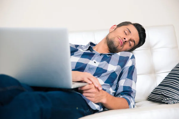 Mann schläft mit Laptop auf dem Sofa — Stockfoto