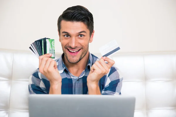 Cheerful man holding credit cards
