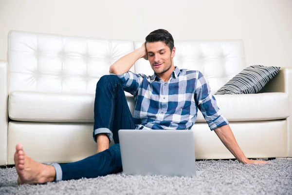 Mężczyzna siedzi na podłodze z laptopem — Zdjęcie stockowe