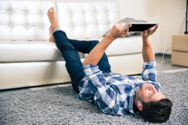 Homem usando tablet computador com fones de ouvido — Fotografia de Stock