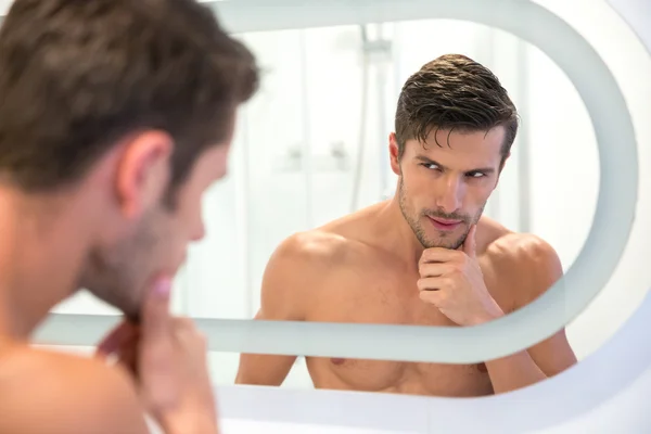 Mężczyzna patrząc na swoje odbicie w lustrze — Zdjęcie stockowe