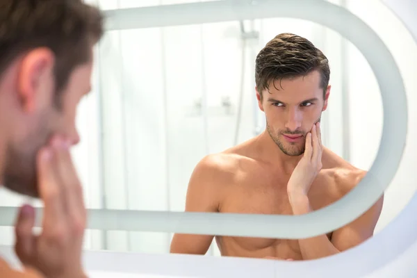 Mann blickt auf sein Spiegelbild im Spiegel — Stockfoto