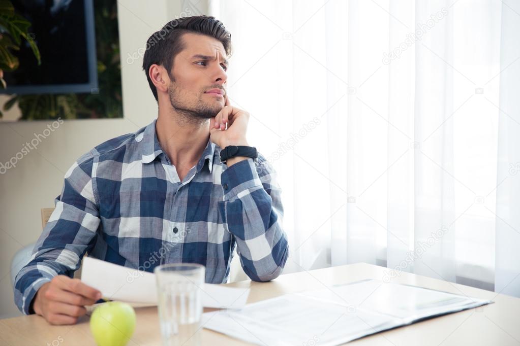 Portrait of a thoughtful man checking bills