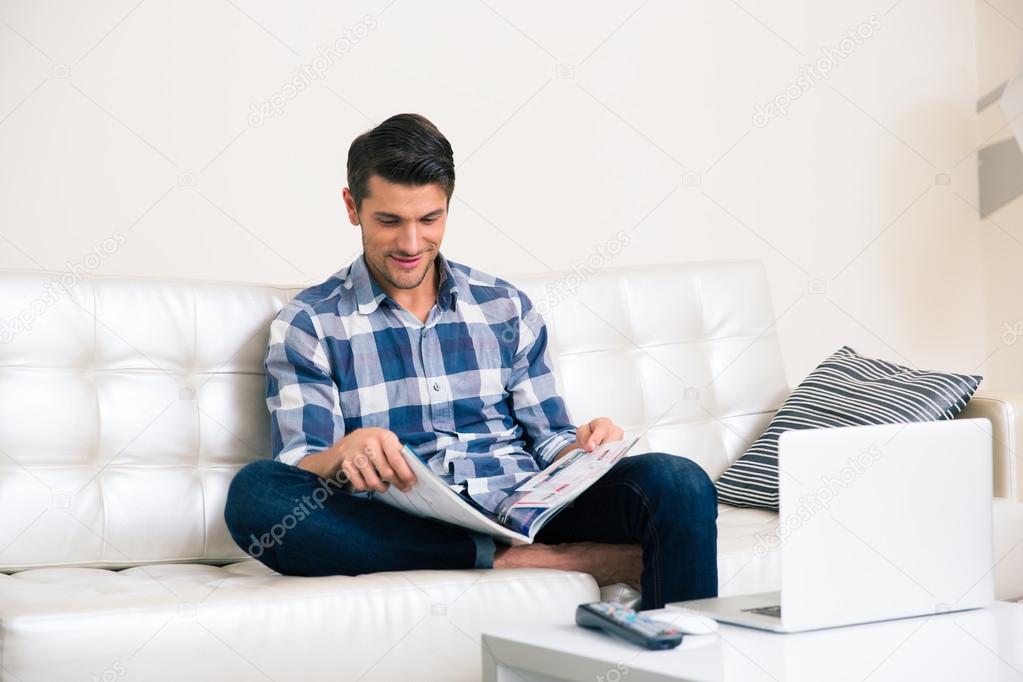 Man reading magazine on the sofa