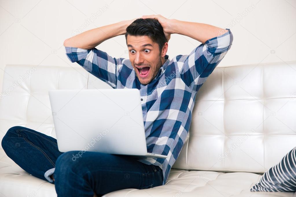 Excited man looking game on laptop
