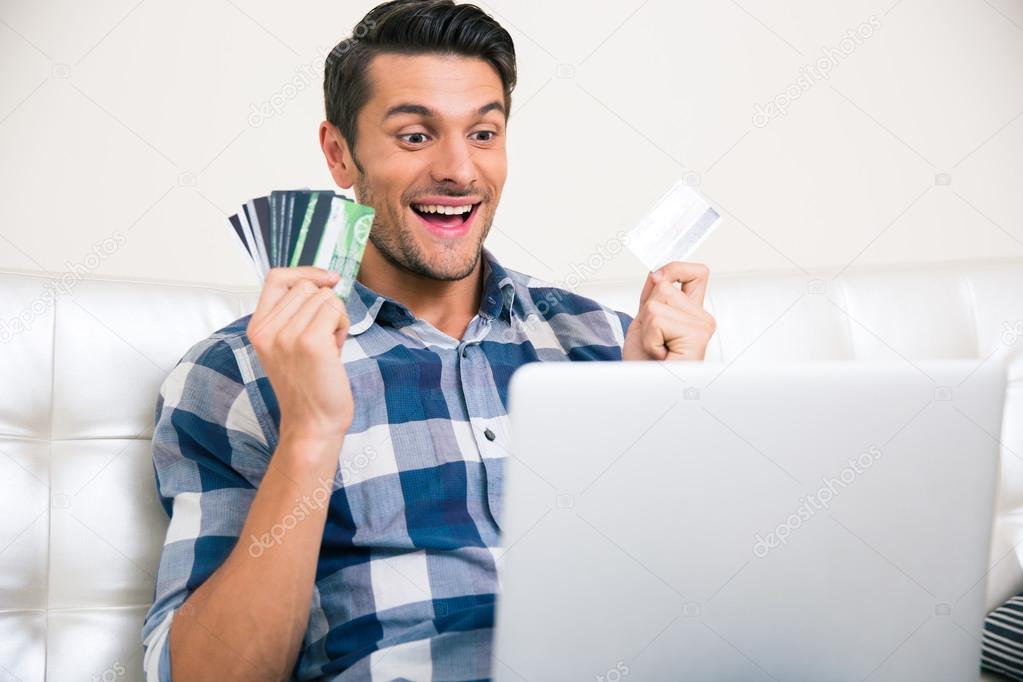 Cheerful man holding bank cards