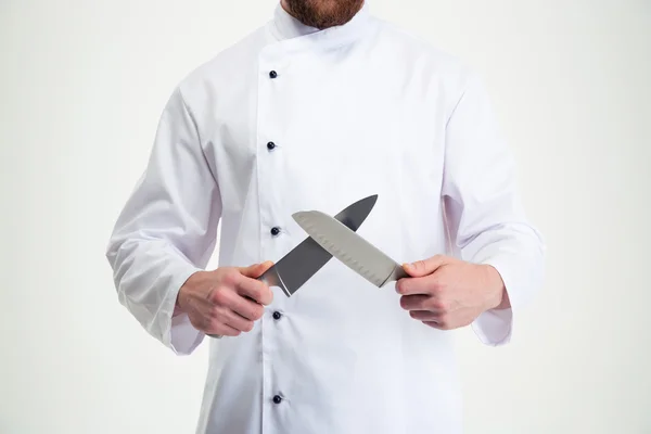 Портрет крупным планом мужчины-повара, затачивающего нож — стоковое фото