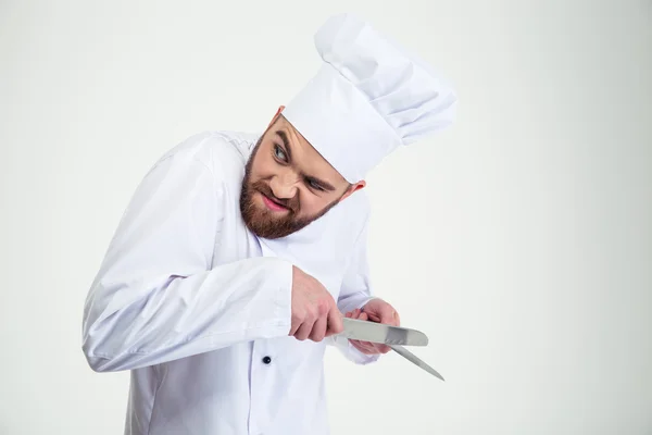 Retrato de um chef masculino cozinheiro afiar faca i — Fotografia de Stock