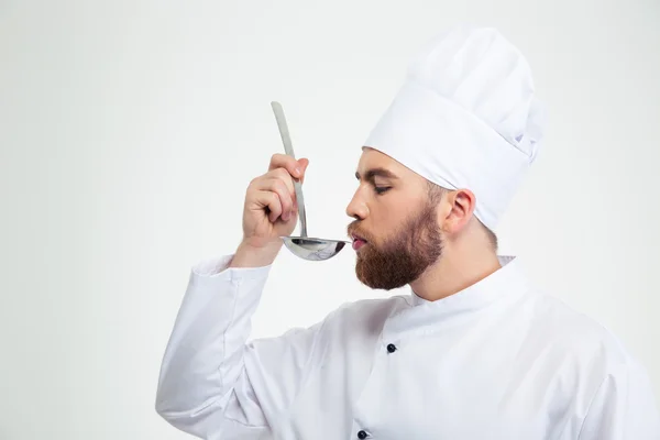 Chef cook holding a soup ladle and smelling it — Stock Photo, Image