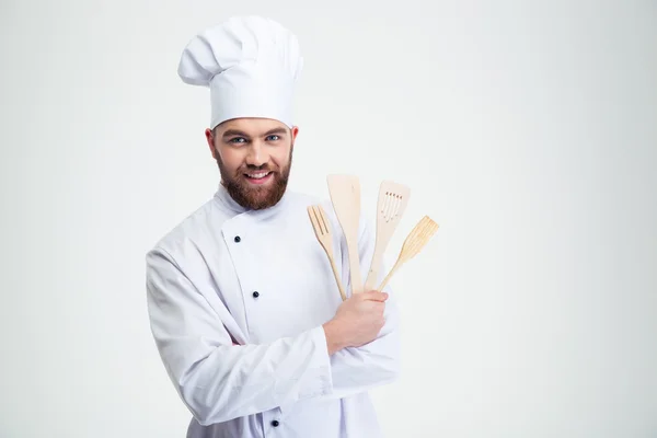 Hombre sonriente cocinero sosteniendo cucharas —  Fotos de Stock