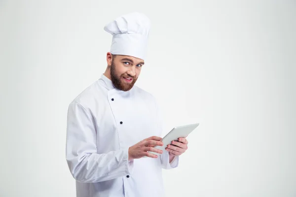 Улыбающийся повар держит планшетный компьютер — стоковое фото