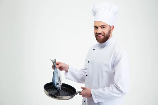 Male chef cook holding pan with fish — Stock Photo, Image