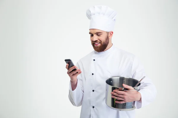 Chef masculino cocinero sosteniendo olla y usando smartphone — Foto de Stock