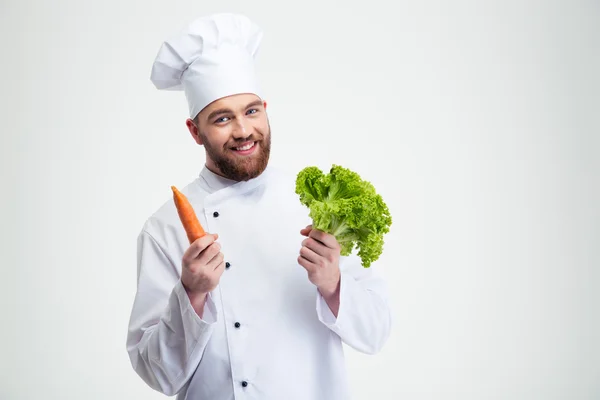 Шеф-повар держит салат и морковь — стоковое фото