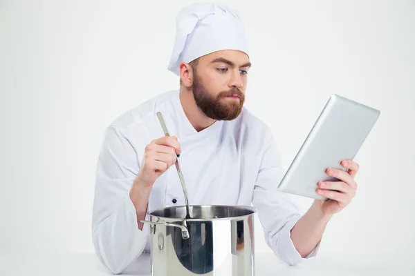 Chef masculino mirando la tableta digital mientras prepara comida — Foto de Stock