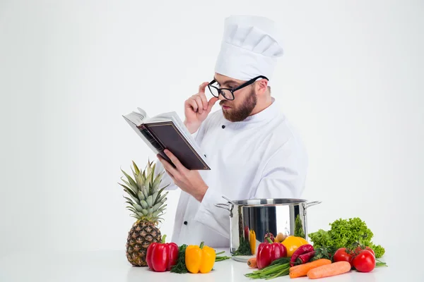 Chef cook in glasses reading recipe book — Stock Photo, Image