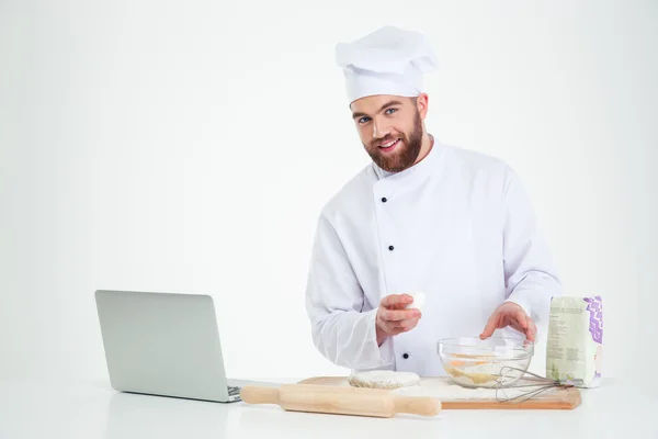 Счастливый повар-мужчина печет с ноутбуком — стоковое фото