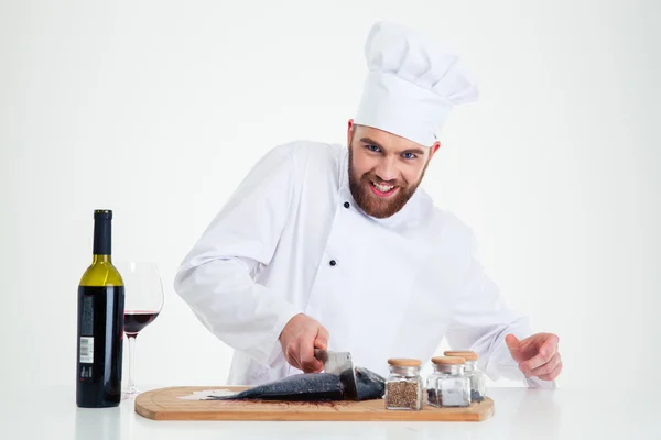 Retrato de um cozinheiro sorridente macho cozinheiro cortando peixe — Fotografia de Stock