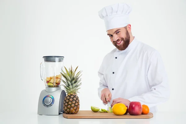 Portréja egy mosolygó férfi szakács szakács vágás gyümölcsök — Stock Fotó
