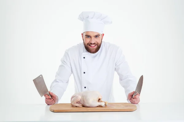 Male chef cook standing with knifes and chicken — Stock Photo, Image