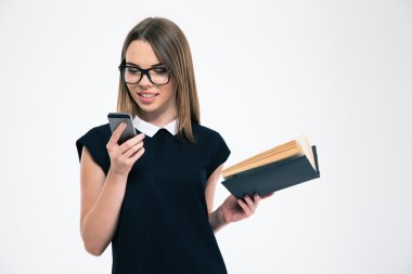 Kız holding kitap gülümseyen ve smartphone kullanarak