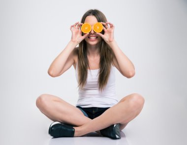 Katta oturan ve portakal gözleriyle kapsayan kız